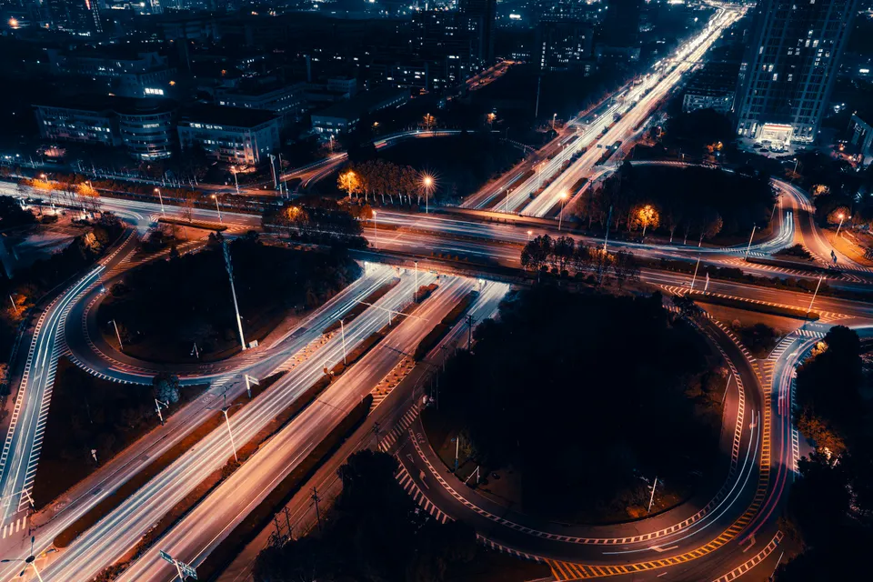 Aerial view of illuminated city highways and interchanges at night