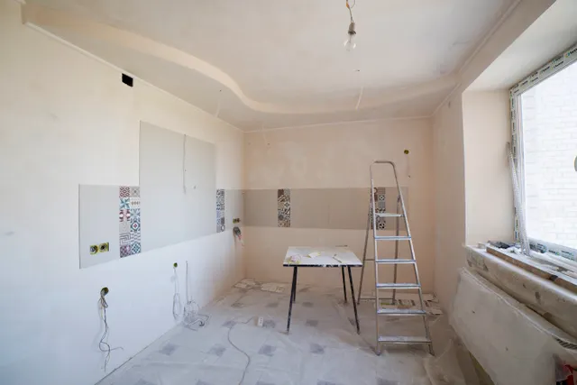 Bright kitchen under renovation with a ladder and tools
