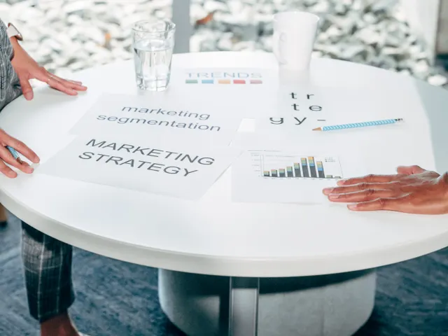Marketing strategy documents with charts and segmentation notes spread across a table